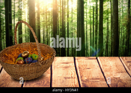 Easter eggs in paper nest basket against view of tropical forest Stock Photo