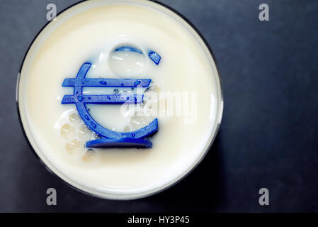 Eurosign sinks into a milk glass, low milk prices, Eurozeichen versinkt in einem Milchglas, niedrige Milchpreise Stock Photo