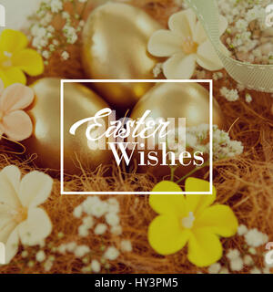 Easter greeting against golden easter eggs with flowers in nest Stock Photo