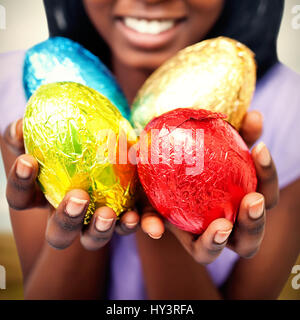 Harvester machine working on field against close up of a woman showing colorful easter eggs Stock Photo
