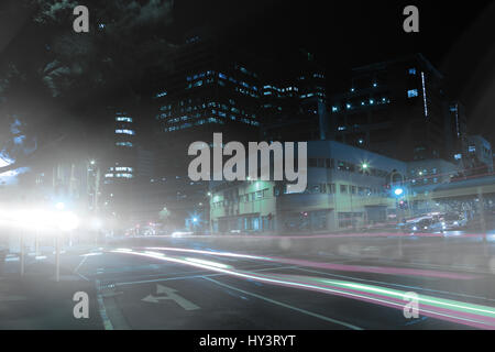 illuminated roads by building in city at night Stock Photo