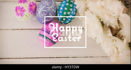happy easter against multicolored easter eggs and white flowers Stock Photo