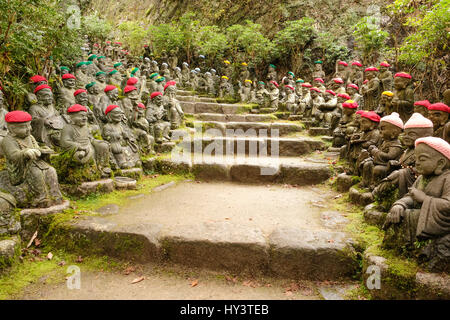 Jizo statues with colourful knitted hats sit on both sides of stone steps in Daisho-in Temple in Miyajima, Japan Stock Photo