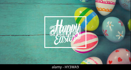 Happy easter against painted easter eggs on wooden plank Stock Photo