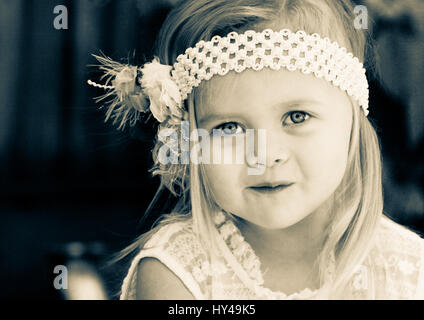 Close up of a sweet little toddler girl wearing an old fashioned headband Stock Photo