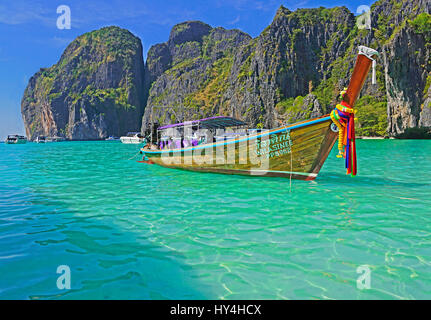 Thai long-tail boat decorated with sashes at Maya Bay of Phi Phi Leh island, Thailand. Stock Photo