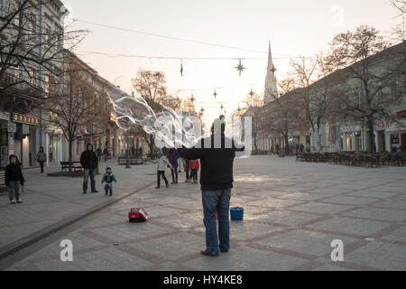 NOVI SAD, SERBIA - DECEMBER 13, 2015: Street performer making soap bubbles in order to amuse people passing by pn Novi Sad main street, Zmaj Jovina  S Stock Photo