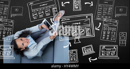 Woman on her tablet looking up against black background Stock Photo