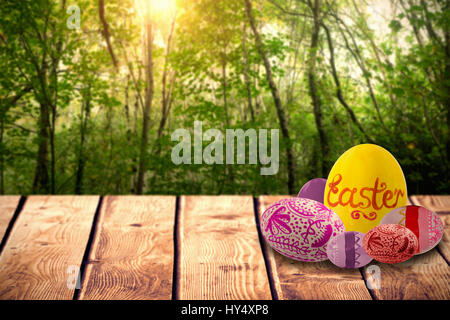 Multi colored patterned easter eggs against green forest Stock Photo