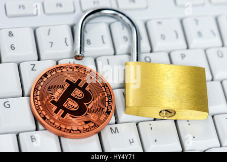 Coin with Bitcoin sign and open castle on computer keyboard, Muenze mit Bitcoin-Zeichen und offenes Schloss auf Computertastatur Stock Photo