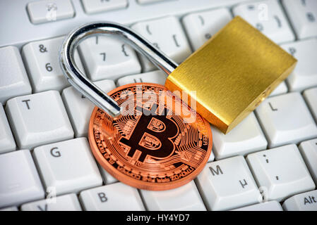 Coin with Bitcoin sign and open castle on computer keyboard, Muenze mit Bitcoin-Zeichen und offenes Schloss auf Computertastatur Stock Photo