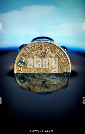 British one-pound coin in the water, low pound course, Britische Ein-Pfund-Muenze im Wasser, niedriger Pfund-Kurs Stock Photo