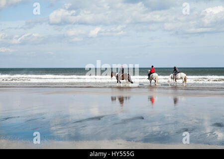 Three women on horses on Saltburn beach in England,UK Stock Photo