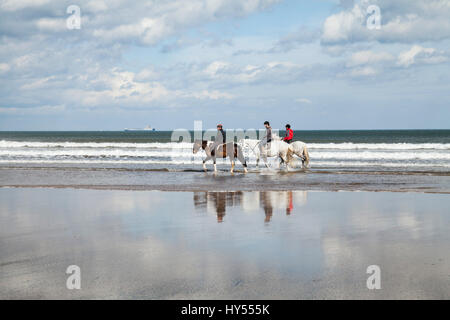 Three women on horses on Saltburn beach in England,UK Stock Photo