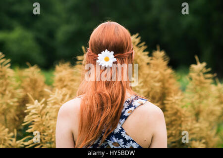 Finland, Pirkanmaa, Tampere, Young woman wearing floral dress and daisy flower in her hair