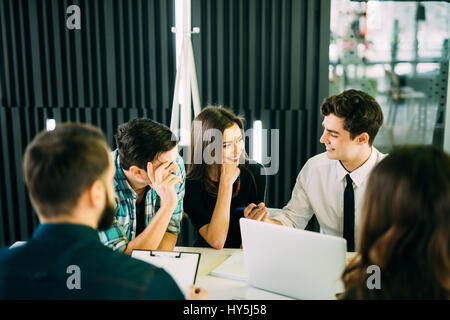 Startup diversity teamwork brainstorming meeting concept. business team coworkers working together at laptop. People working planning start up. Group  Stock Photo