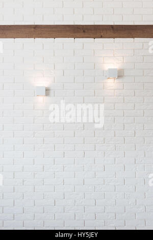 White brick wall with two lights and wooden beam Stock Photo