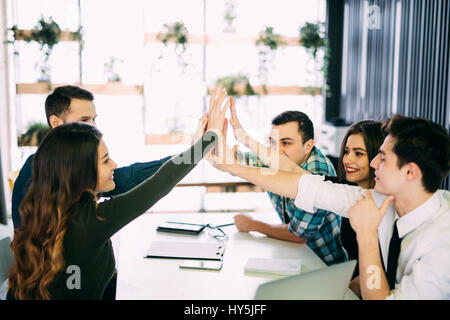 Photo editors giving high-five in meeting room at creative office room Stock Photo