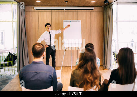 Web designers standing at office planning website layout on flipchart in office Stock Photo