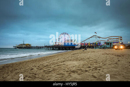 SANTA MONICA, CALIFORNIA, USA - MAY 29, 2016 : Santa Monica Pier with many visitors at a cloudy evening,  Los Angeles, California. Stock Photo