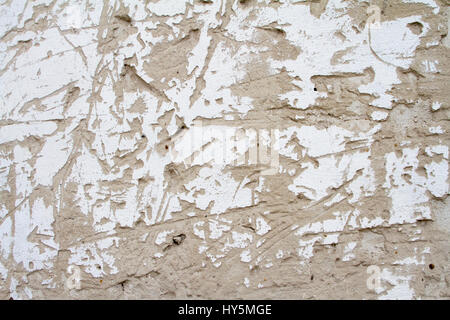 Vintage background texture of old brick masonry on ancient cement with cracks with traces of old paint. Stock Photo