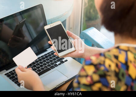 Woman holding smartphone and credit card for online shopping payment. E-commerce using internet and mobile application concept Stock Photo