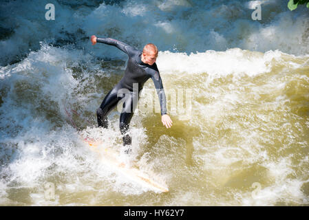 Munich, Germany - June 7, 2016: Boarders surfing on the Isar river in Munich, Bayern, Germany