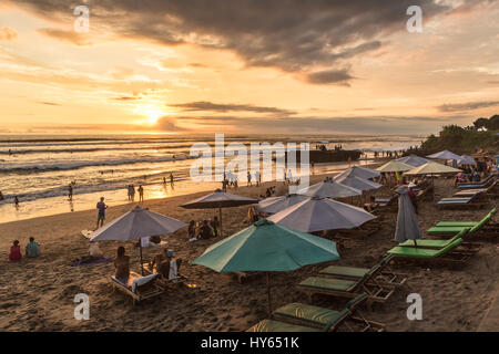 BALI, INDONESIA - FEBRUARY 18, 2017: People enjoy the sunset over Canggu beach, north of Kuta and Seminyak, in Bali in Indonesia. Canggu is popular wi Stock Photo