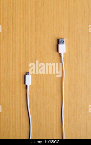 White USB cable with standard and micro port on the wooden background vertical Stock Photo