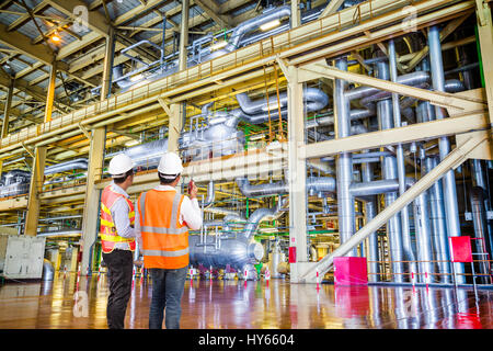 Engineer working in a thermal power plant with talking on the walkie-talkie for controlling work Stock Photo