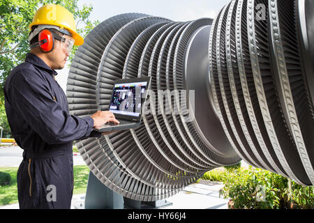 Engineer using laptop computer for maintenance steam turbine of thermal power plant Stock Photo