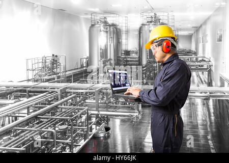 Industrial engineer checking machine status with laptop computer Stock Photo