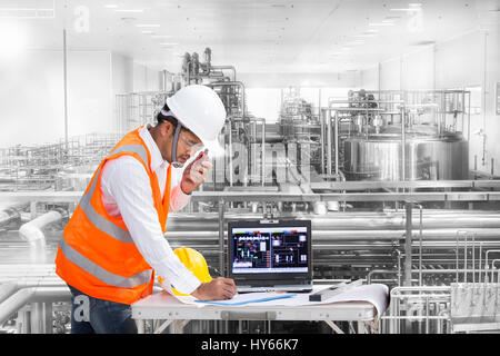 Industrial engineer checking machine status with laptop computer Stock Photo