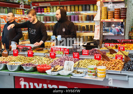 JERUSALEM, ISRAEL - DECEMBER 29, 2016: The sellers of pickled olives in the market of Mahane Yehuda in Jerusalem. More than 250 sellers sell fruits, v