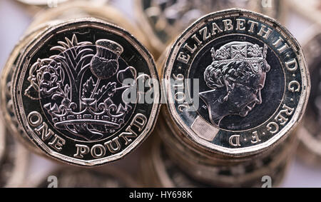 new pound coin introduced in Britain in 2017, front and back,  on a stack of coins Stock Photo
