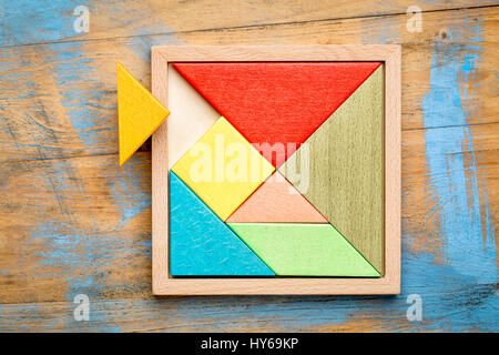 Tangram, a traditional Chinese Puzzle Game made of different wood parts to build abstract figures from them Stock Photo