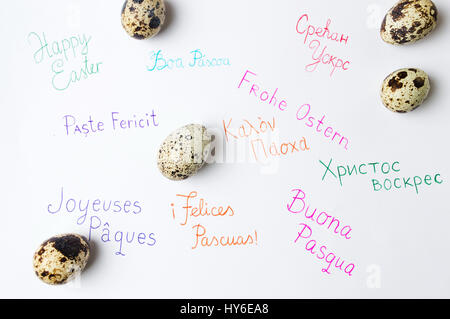 Happy Easter note in different languages and quail eggs Stock Photo