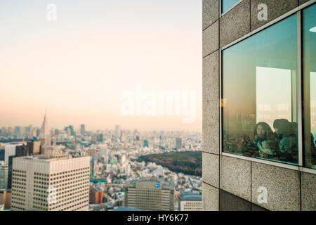 TOKYO  - JAPAN - JANUARY 11, 2017 Girls are enjoying the view from the top of the Tokyo Metropolitan Government Office at sunset. The Tokyo Metropolit Stock Photo