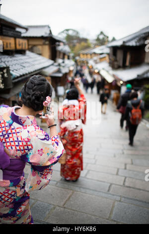KYOTO, JAPAN - JANUARY 10 2016 : Japanese women in traditional Kimono are taking photos an selfie on the way to Kiyomizu-Dera temple in Kyoto. Kyoto i Stock Photo