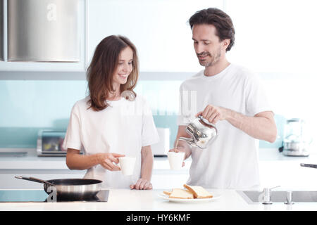 Happy couple cooking breakfast together in the kitchen Stock Photo