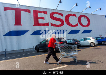 Tesco Store supermarket sign, logo, elderly customer woman with a shopping cart Tesco trolley Czech Republic Stock Photo