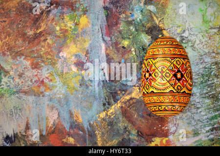 painted easter wooden egg on a multi-colored background Stock Photo