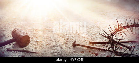 Passion Of Jesus Christ - Hammer and Bloody Nails And Crown Of Thorns On Arid Ground Stock Photo