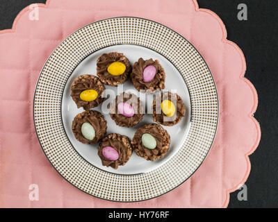 Easter Chocolate Crispy Cereal Nests With Mini Easter Eggs Against a Pink Background Stock Photo