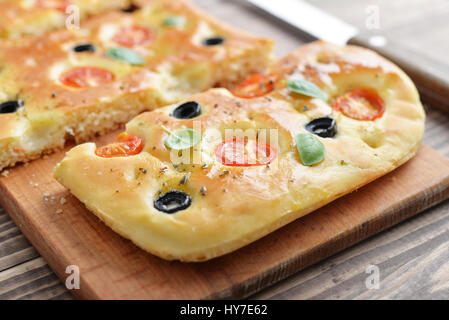 Italian food -  traditional focaccia with cherry tomato and olives on wooden background Stock Photo