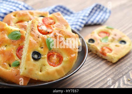 Italian food -  traditional focaccia with cherry tomato and olives on wooden background Stock Photo