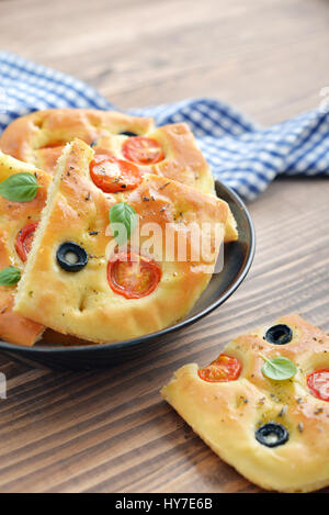 Italian food -  traditional focaccia with cherry tomato and olives on wooden background Stock Photo