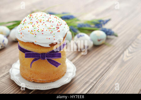 Easter cake with colorful eggs and flowers on wooden background Stock Photo