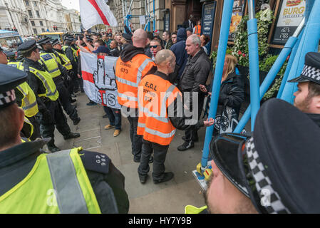 London, UK. 1st Apr, 2017. London, UK. 1st April 2017. Marches and rallies by Britain First and the EDL (English Defence League) in reaction to the London terror attack were opposed by the Anti-Fascist Network, London Antifascists and Unite Against Fascism (UAF) who accuse the extremist right of using the attack to fuel their anti-Muslim and anti-migrant racist propaganda. EDL supporters outside a pub are protected by police as they shout across the road at anti-fascists. Peter Marshall ImagesLive Credit: Peter Marshall/ImagesLive/ZUMA Wire/Alamy Live News Stock Photo