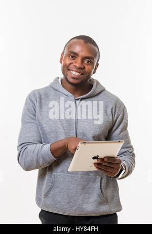 An African man uses a tablet in a studio environment. Stock Photo